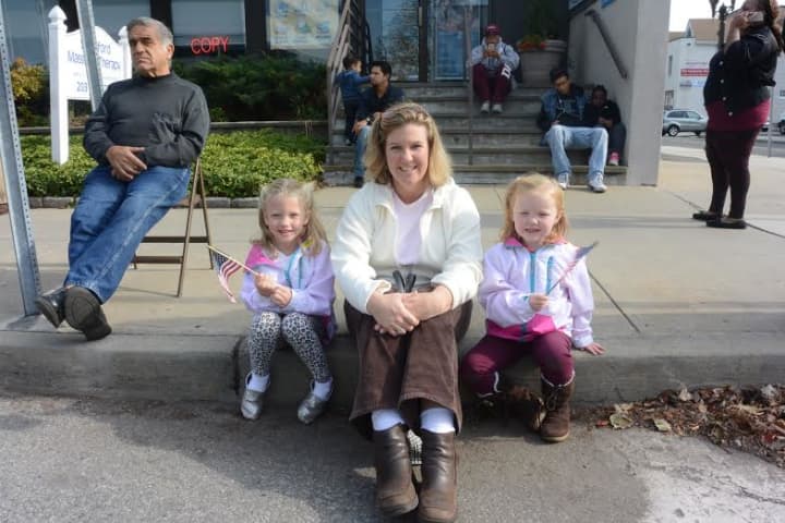 Kerry Chillo and her daughters patiently wait for the parade to begin in downtown Stamford.
