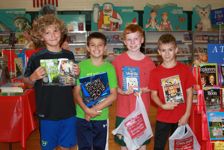Holmes School fifth-graders Wyatt Marcous, James Tomasello, Jack Walsh and Lance Anavy from Micaela Tucker&#x27;s class visit the book fair.