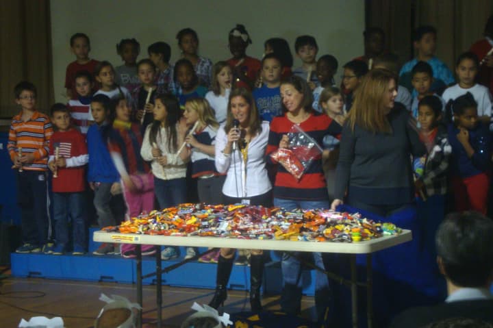 Naramake Principal Patti Mattera and members of the PTO unveil how much candy the students donated for the troops during the candy drive.