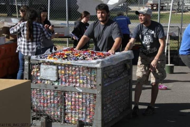Volunteers help sort through the hundreds of pounds of candy donated to the troops.