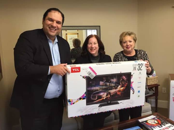 Donna Eastman receives her flat screen television from Houlihan Lawrence&#x27;s Yorktown brokerage.