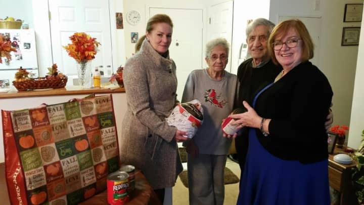 Putnam County Executive MaryEllen Odell, left, and Office for Senior Resources Patricia Sheehy, right, present a Thanksgiving turkey and a bag filled with traditional Thanksgiving trimmings to Gloria and Martin Szabo of Carmel.