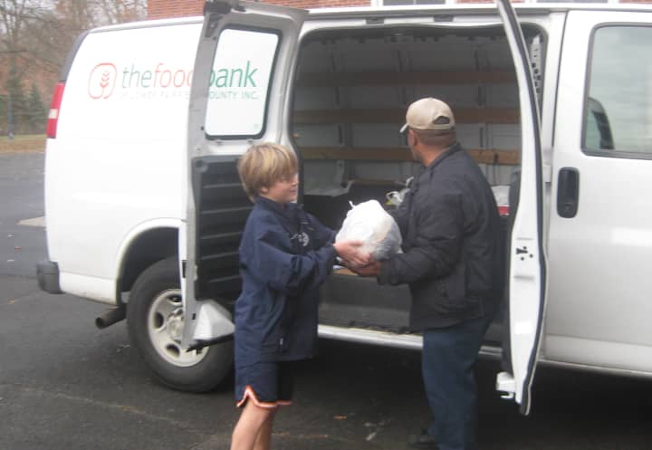 Fifth-grader Tauson Pfeifle donates a turkey to the Food Bank of Lower Fairfield County as part of Royle&#x27;s annual Thanksgiving food drive.