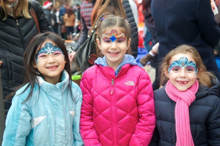 Seven-year-olds Emi Takegami, left, Elina Francis, middle, and Laetitia Clauss, right of Rye show off their painted faces.