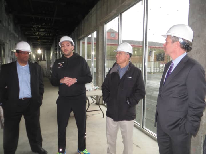 White Plains Recreation and Parks Director, far left, stands inside the future tennis clubhouse with Cesar Andrade, director of operations. Mayor Tom Roach is on the far right.