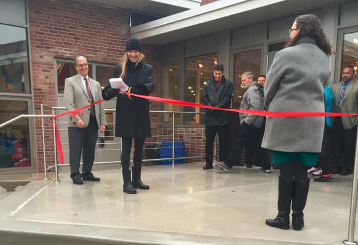 Sue Groner cuts the ribbon for the FAME courtyard at Fox Lane High School.