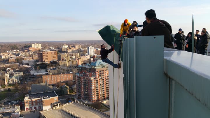 Fox 5 Sports anchor Duke Castiglione hangs over the edge of Stamford&#x27;s Landmark Square building, 22 stories above the street, during Friday&#x27;s rehearsal for Heights &amp; Lights.