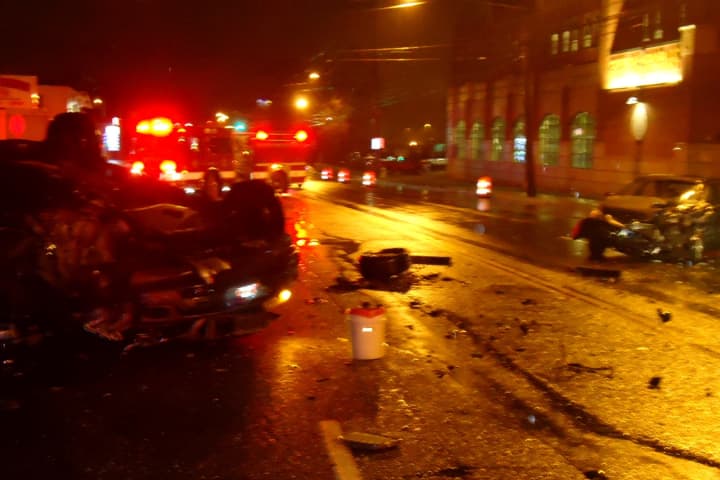 A SUV hit a compact car outside the Norwalk Fire Department headquarters Friday night, knocking the SUV onto its roof.