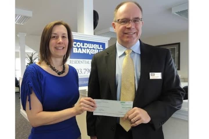 Lori Zezza, left, associate director of events and publicity for Anns Place in Danbury, and accepts a $520 donation from Scott Cooney, branch manager of the Coldwell Banker Residential Brokerage office in Danbury.