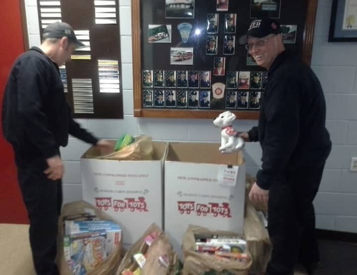 From left, Wilton firefighters Brian Elliott and Bryan Montgomery painting signs for the U.S. Marine Corps Reserve Toys for Tots Program.