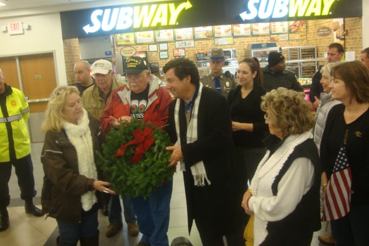 Karen Worcester of Wreaths Across America presents a wreath to Paul Landino of Project Service at the service plaza on I-95 Southbound in Darien.