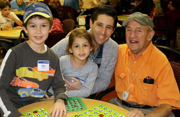 The Goldfein family of New Rochelle play bingo with a Kittay House resident.