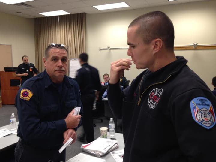 Yonkers Firefighter Chris Leal assisting Probationary Firefighter Steven Roche with swabbing his cheek to register for the program.
