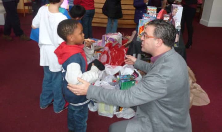 Vinnie Fusco general manager and executive in charge of production at NBCUniversals Stamford Media Center talks with Gemere McIntosh, 6, during a toy donation by NBCUniversal staff in Stamford on Wednesday.