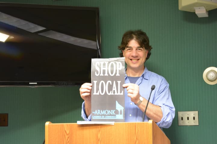 Michael Levy holds a mock-up of the Armonk Chamber&#x27;s proposed &quot;Shop Local&quot; banners.