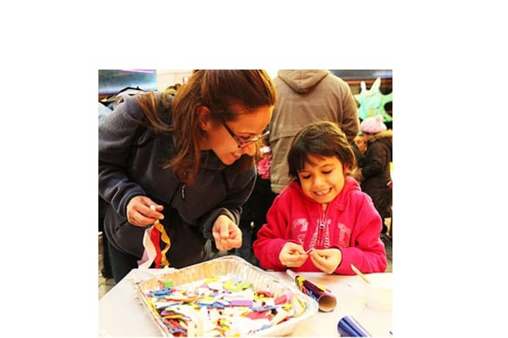 A girl enjoys a craft with an adult at Ring In The New Year at New Roc City last year.