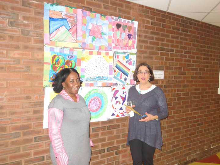 Leslie Harrison and Kathy Yacoe Skura stand in front of a collage quilt inspired by Faith Ringgold&#x27;s book &quot;Tar Beach.&quot;