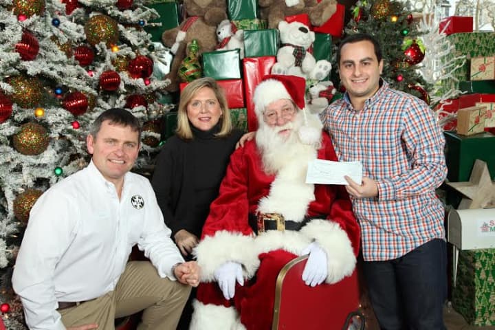 Branden Hahn of Kids in Crisis visits Santa at McArdles to accept a donation of $2,465 from James McArdle of McArdles and Tammi Ketler of TMK Sports &amp; Entertainment. 
