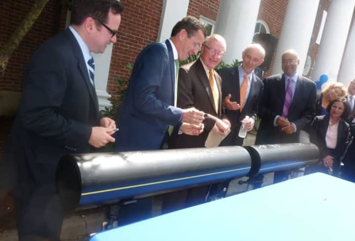 Gov. Dannel P. Malloy, second from left, jokes with Wilton First Selectman Bill Brennan, center, after they and other officials signed an 8-inch polyethylene pipe during a press conference Aug. 4 announcing the expansion of Yankee Gas into the town. 