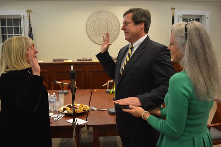 Don Scott takes his oath of office with his wife, Stephanie, at the the right. Town Clerk Boo Fumagalli, left, administers the oath.