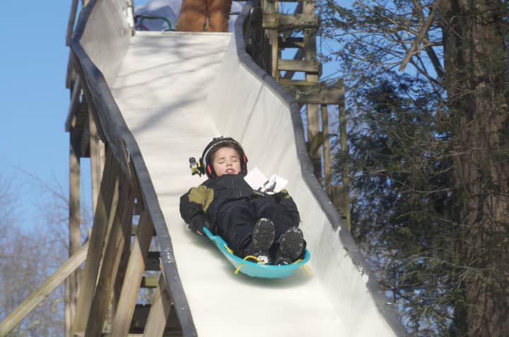 A youngster heads out of the starting gate on the backyard luge course in Ridgefield.