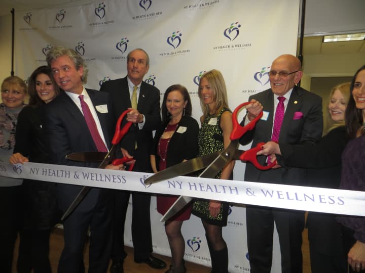Dr. Timothy Morley, medical director at NY Health &amp; Wellness, left, cuts the ribbon to his new center with Harrison Mayor Ron Belmont, right, as staff and other public officials look on Wednesday.