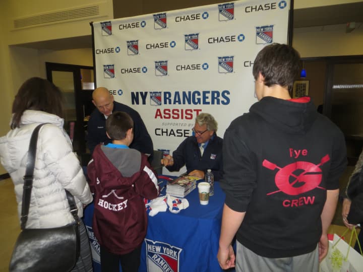 Adam Graves, standing at left, and Glenn Anderson, seated, swapped hockey win memories as they signed autographs in Rye on Tuesday.