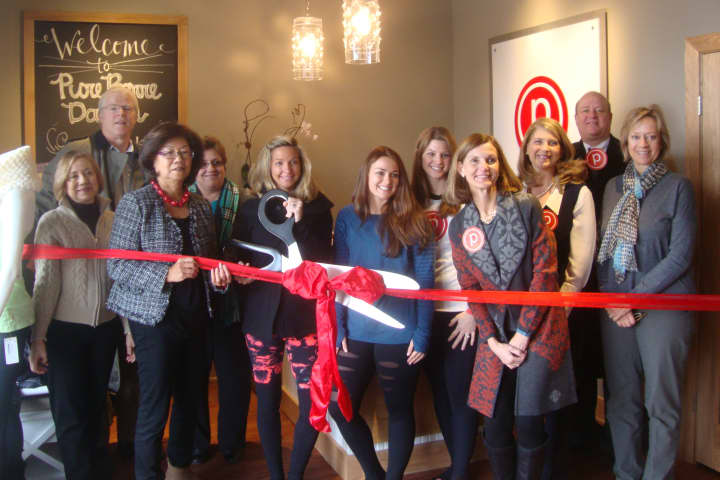 The staff of Pure Barre celebrates the opening of the new studio with a ribbon cutting alongside members of the Darien Chamber of Commerce.