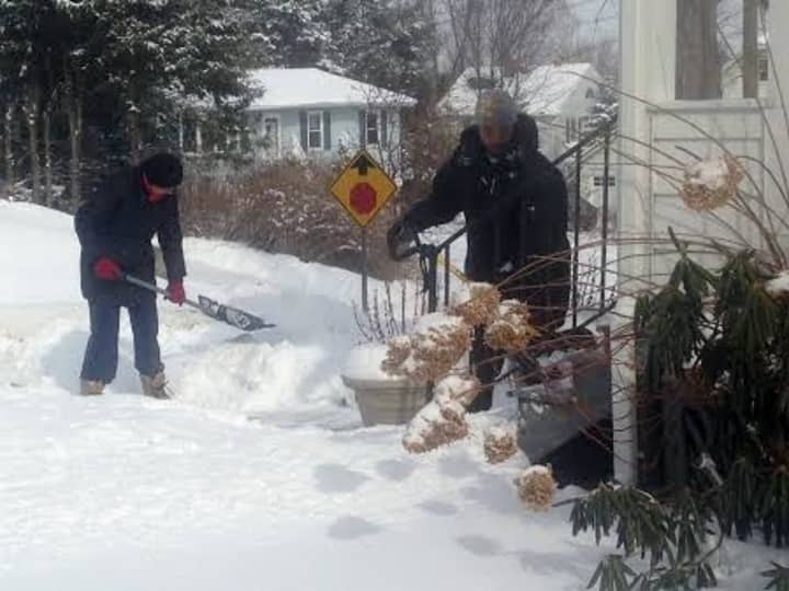 Two neighbors team up to dig out a third neighbor on Wilson Street in Danbury on Tuesday. 