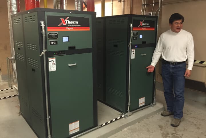 Norwalk Buildings and Facilities Manager Alan Lo displays the new energy-efficient condensing boilers installed at City Hall. 
