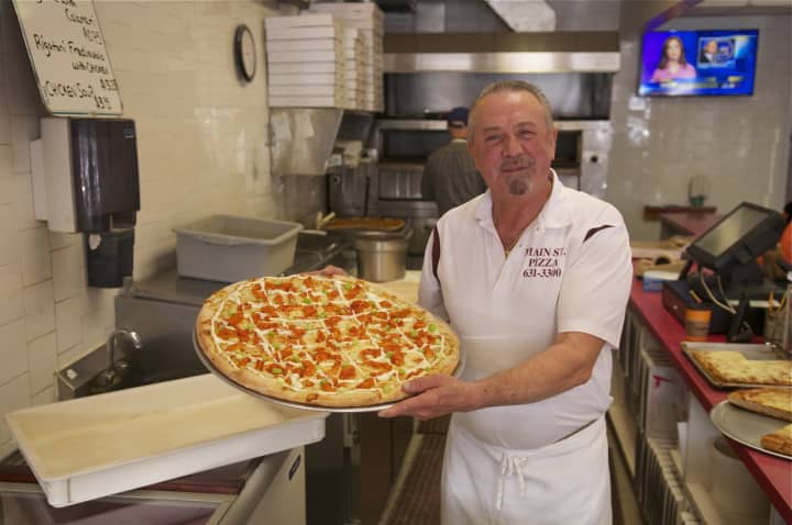 Main Street Pizza Owner Joe Barbosa shows off one of his pies.