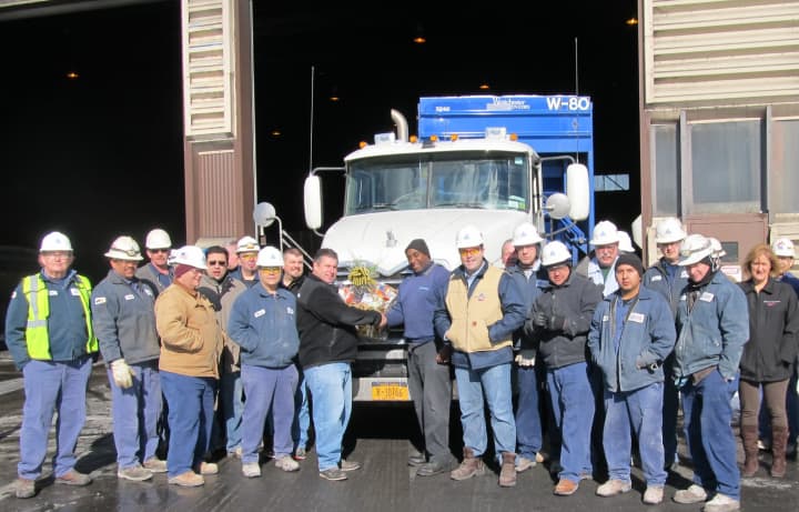 Wheelabrator Westchester employees join Plant Manager Brett Baker and Operations Manager Phil Schwer to present a gift basket to City Carting driver Mike McKenzie as the energy-from-waste plant surpassed the 20 million ton mark.