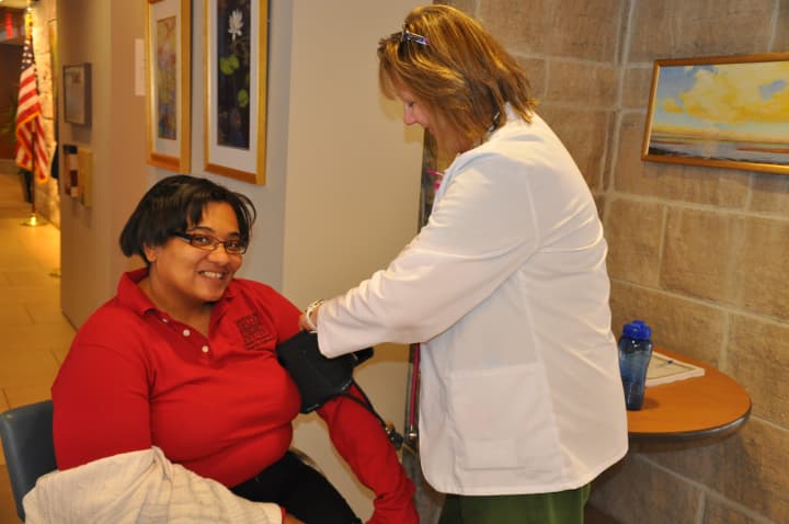 Cardio-pulmonary Manager Debbie Petranchik takes the blood pressure of employee Leslie Marie Bristow at the 2014 Healthy Heart Fair. 
