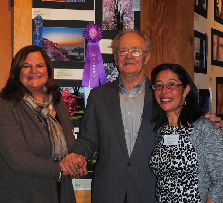Tree Conservancy of Darien board members Karen Hughan, left, and Sabina Harris, right, stand with Stanley Malecki, winner of Best in Show at the 2014 Celebration of Trees photography contest.