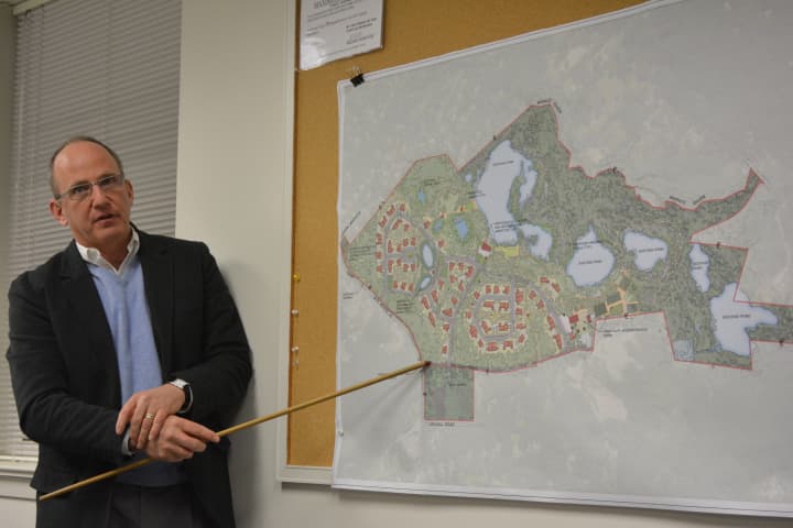Developer William Balter stands next to a site plan for his housing proposal, currently called Bedford Farm.