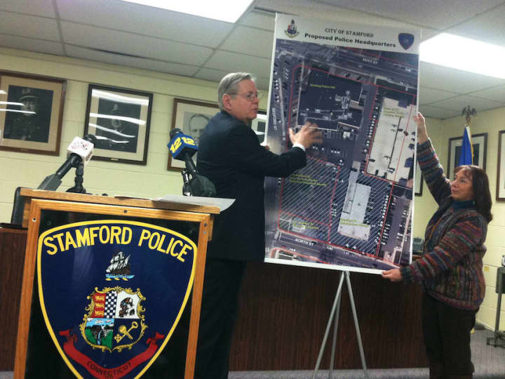 Mayor David Martin points to a plan to move the current police headquarters onto the site of the current Hoyt Barnum House. Pam Coleman, historical society president, is helping to hold the enlarged photograph.