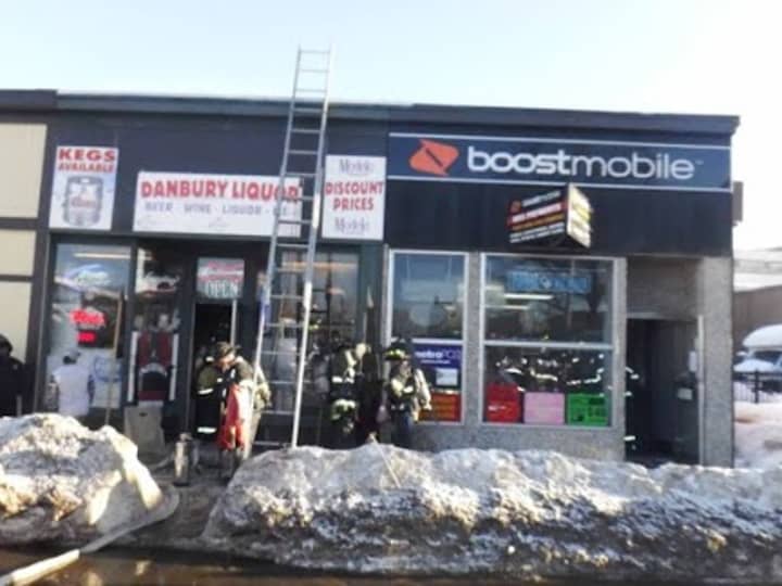 Danbury firefighters douse a blaze at a Boost Mobile store at 20 White St. on Friday.