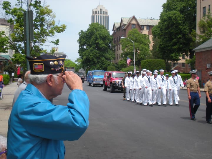 John Condelario of New Rochelle salutes the uniformed men and women marching on North Avenue.