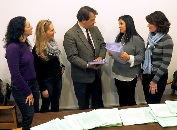 Harrison Central School District Advocacy Committee members hand petitions to state Sen. George Latimer, D-Rye