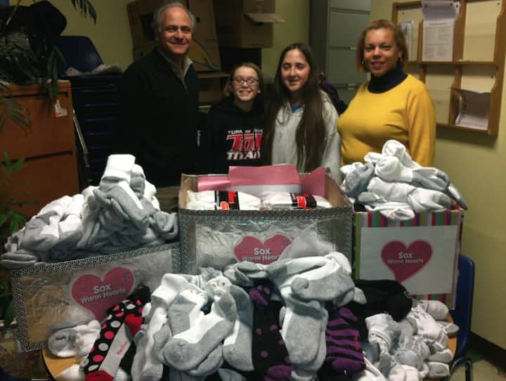 Turn of River Middle School students donate 500 pairs of socks to New Covenant House of Hospitality Friday. From left are: John Gutman from New Covenant, students Mason Perkins and Hannah Nekritz, and Betsy Lopez, from New Covenant.