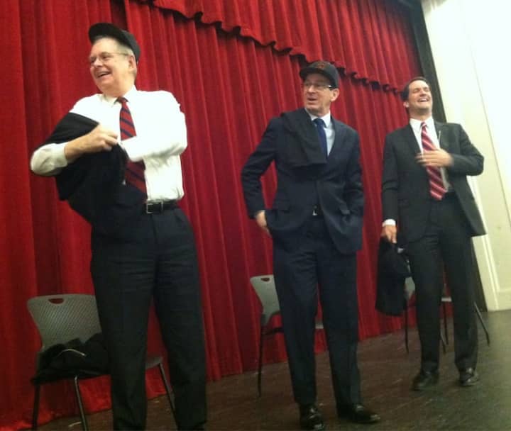 Gov. Dannel P. Malloy, center, shares a laugh with U.S. Rep. Jim Himes, right, and Stamford Mayor David Martin, as Martin slips on a Stamford High T-short following a senior class assembly with the three politicians.