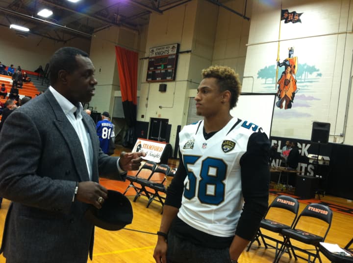 Former NFL player Craig Bingham talks with current Jacksonville Jaguar player Khairi Fortt at the Stamford High Pride Day. Bingham graduated in 1978 while Fortt graduated in 2010.