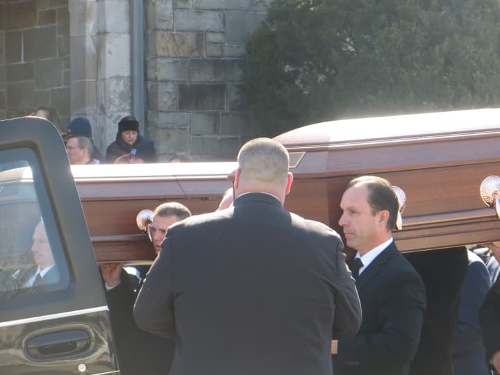 The caskets for Alissa and Deanna Hochman glisten in the sunlight as they are carried out of St Gregory the Great Church in Harrison