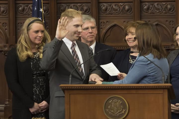 Stephen Harding, with a hand on his great-grandfathers Bible and surrounded by loved ones, is sworn in as state representative of the 107th District by Secretary of the State Denise Merrill in the House Chamber.