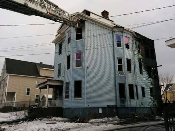 Bridgeport firefighters douse the blaze at a three-story multifamily home on Wednesday afternoon.