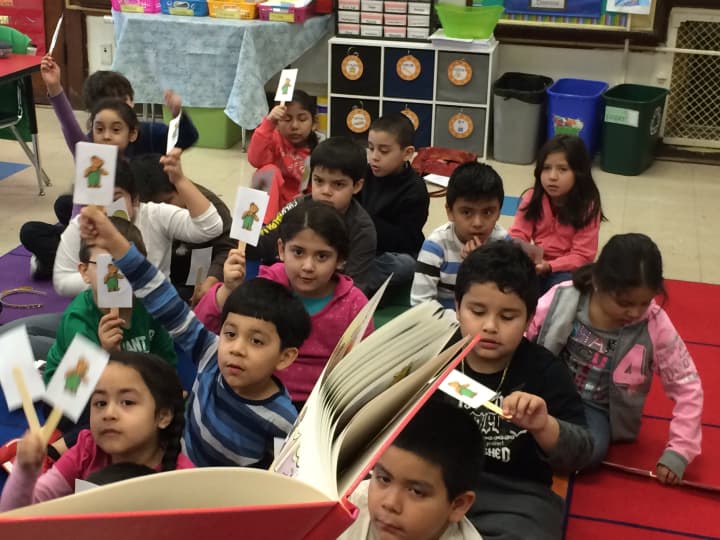Students in Ms. Lezajas first-grade class use stick puppets as they listen to the book &quot;Corderoy.&quot;