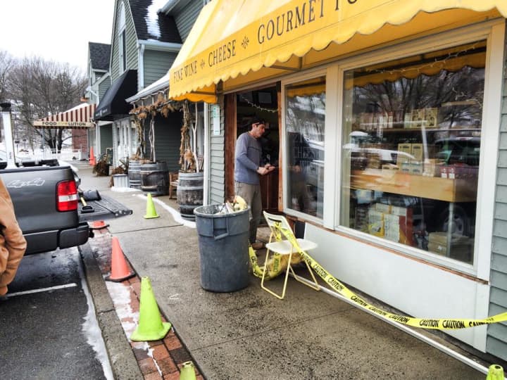 A worker repairs the damage at 109 Cheese &amp; Wine in Ridgefield after a car hit the building Wednesday. 