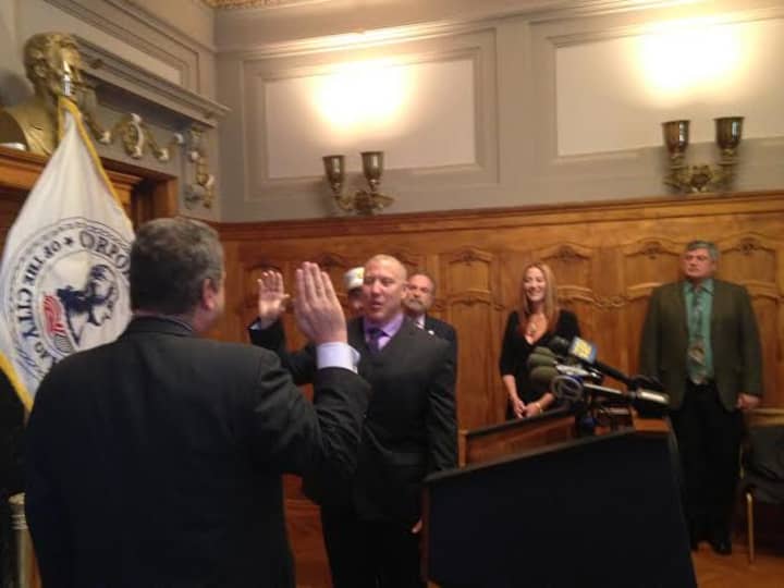 Mayor Mike Spano swears in Commissioner John Darcy as his wife Sherry looks on.