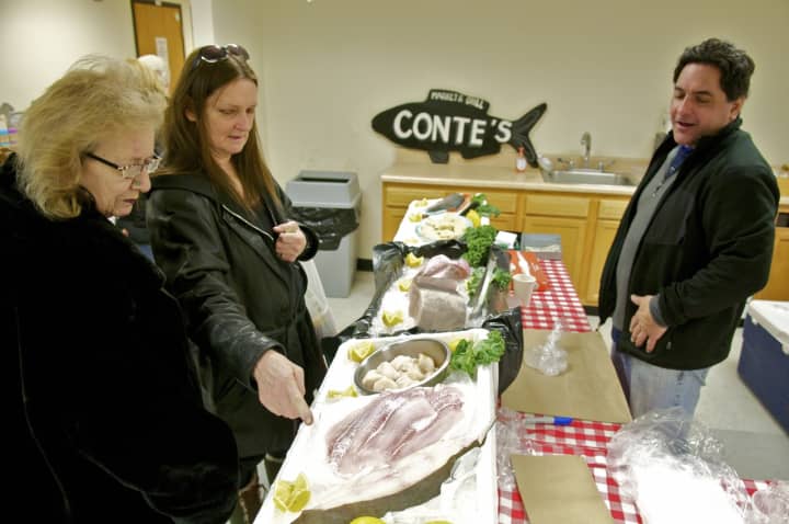 Dean Conte (R) of Conte&#x27;s Fish Market in Mount Kisco helps customers at the Farmer&#x27;s Market.