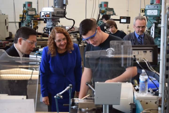 U.S. Rep. Elizabeth Esty and Deputy Labor Secretary Chris Lu look on as Abbott Tech sophomore Philip LoPiano works in the manufacturing lab at the Danbury technical high school.